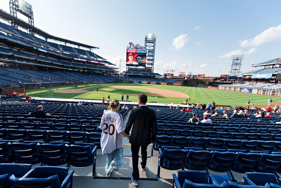 A wedding couple walk down to the Phillies field before the game starts.